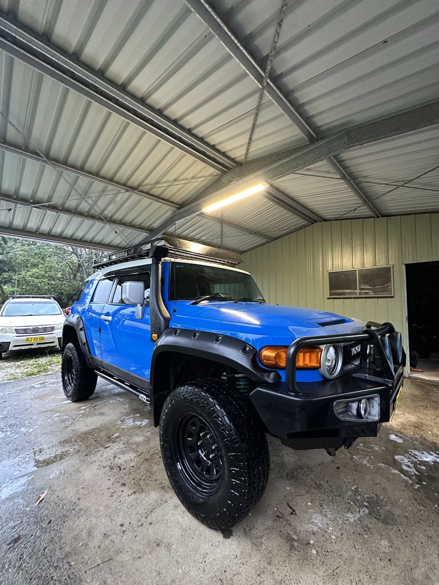 Blue Toyota FJ Cruiser washed under a carport